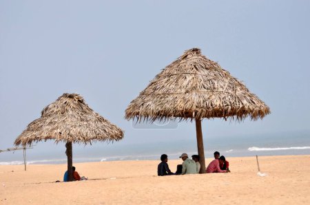 Téléchargez les photos : Touristes sous parasols à la plage, Puri, Orissa, Inde - en image libre de droit