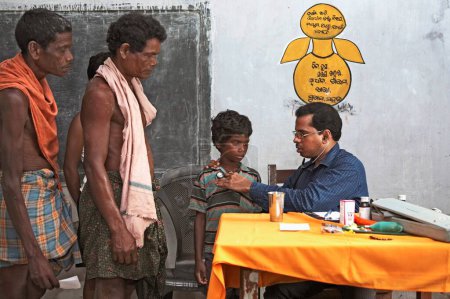 Foto de Médico examinando la salud de aldeanos pobres en chequeo de salud, iniciativa de campamento iniciado por ONG Chinmaya Organización de Desarrollo Rural CORD, Deuladiha, Orissa, India - Imagen libre de derechos