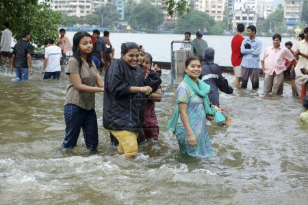 Téléchargez les photos : Inondation due à de fortes pluies, Affichage de personnes marchant dans l'eau de pluie accumulée, Mousson pluie record du monde sur la route de Jambhali Naka à la gare de Thane, adjacente à Masoonda Talao, Shivaji Path, Thane, Maharashtra, Inde - en image libre de droit