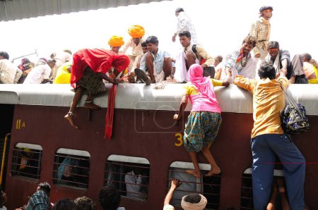 Photo for People climbing on roof of train for risky travel, Marwar railway station, Rajasthan, India - Royalty Free Image