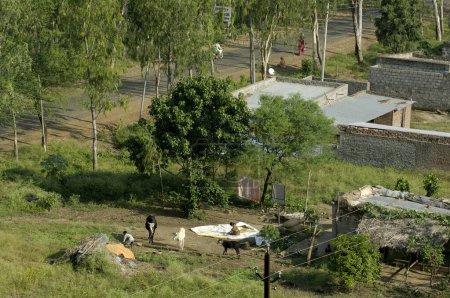 Téléchargez les photos : Vue d'une maison de fermiers depuis le haut du réservoir d'eau à Ralegan Siddhi près de Pune, Maharashtra, Inde - en image libre de droit