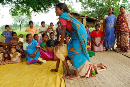 Téléchargez les photos : Ho tribes women playing piggybackking and sharing medical information, Chakradharpur, Jharkhand, Inde - en image libre de droit