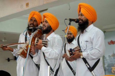 Foto de Sacerdotes acompañados por músicos en su continua entonación del camino de Sri Akhand, lectura incesante del sahib Gurugranth que dura más de 70 horas Templo Dorado, Amritsar, Punjab, India - Imagen libre de derechos