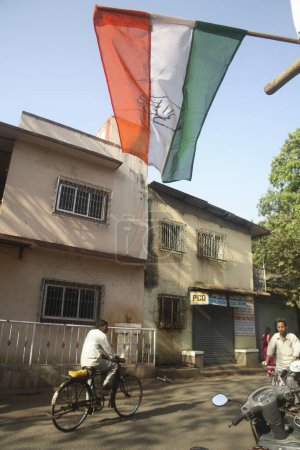 Téléchargez les photos : Vélo et drapeau électoral tricolore indien du congrès scène de rue du parti politique du bazar Somvari, Mulund Bombay Mumbai, Maharashtra, Inde - en image libre de droit