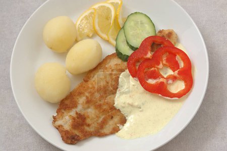 Food , Fried fish (Pangausuise filed Vietnamese fish farmed in rice fields ) with Danish remold sauce and cooked potatoes garnished with cucumber and red bell peppers and slices of lemon