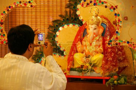 Téléchargez les photos : Élégante idole de seigneur Ganesh ganpati éléphant tête dieu porter collier de perles et gemme synthétique cloutés bijoux avec belle décoration tout autour fait avec des gemmes synthétiques ; Bombay Mumbai ; Maharashtra ; Inde - en image libre de droit