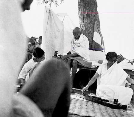 Foto de Mahatma Gandhi, Abha Gandhi y Rajkumari Amrit Kaur spinning, 1944 - Imagen libre de derechos