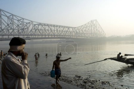 Foto de Vista del puente Howrah (Rabindra Setu) desde Ghat On The River Hooghly Un milagro de la habilidad de ingeniería; Enorme voladizo y puente ancho; Calcuta; Bengala Occidental; India - Imagen libre de derechos
