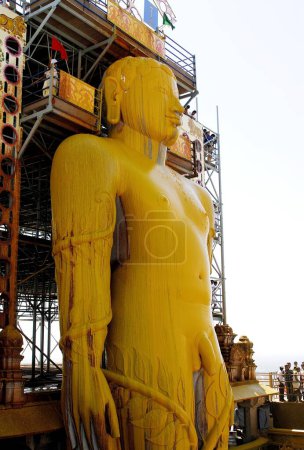 Photo for Jain Devotees Pouring Turmeric Water on forehead head of 58.8 feet monolithic Statue of jain saint Gomateshwara, Lord Bahubali, in Mahamastakabhisheka, head anointing ceremony, on the Vindhyagiri hill, Shravanabelagola, Karnataka, India - Royalty Free Image