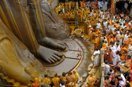 Téléchargez les photos : Pied de 58,8 pieds monolithique Statue de saint jain Gomateshwara seigneur Bahubali recouvert curcuma avec dans Mahamastakabhisheka tête cérémonie d'onction ; Sravanabelagola, Karnataka, Inde - en image libre de droit