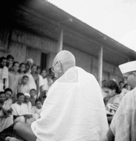 Téléchargez les photos : Mahatma Gandhi s'adressant à des personnes à l'Ashram de Sevagram, 1945, Pyarelal Nayar, Inde - en image libre de droit