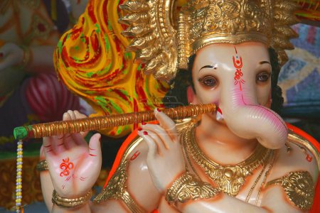 The idol of Lord Ganesh, the elephant headed god, is depicted like Lord Krishna playing a flute, Ganesh ganpati Festival , India
