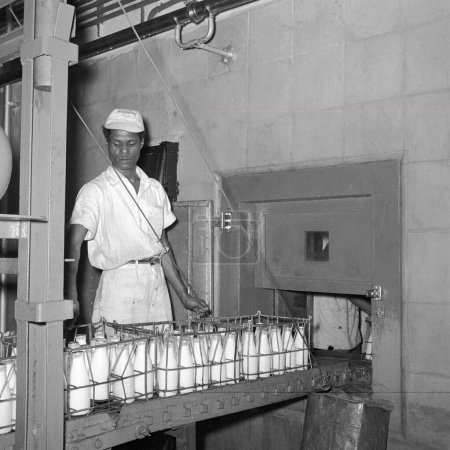Foto de Botellas de leche preparándose para su envío, planta de leche, Aarey, Bombay ahora Mumbai, Maharashtra, India - Imagen libre de derechos