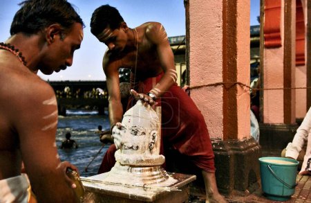 Téléchargez les photos : Une idole lavée au "maakhan" (crème caillée) sur les rives du Godavari avant les prières du soir à Nasik, Maharashtra, Inde - en image libre de droit