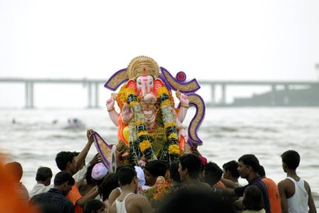 Téléchargez les photos : Personnes immergeant Idol du seigneur Ganesh ganpati à la plage de Dadar ; Mumbai Bombay ; Maharashtra ; Inde - en image libre de droit