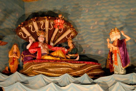 Photo for Lord Vishnu resting on serpent Sheshnaga with Laxmi and lord Bramha ; Huge and magnificent decoration for Ganapati festival ; Pune ; Maharashtra ; India - Royalty Free Image