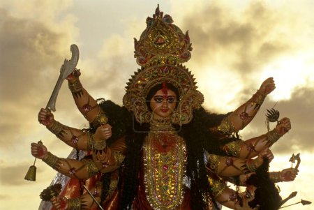 Téléchargez les photos : Déesse Durga Pooja puja immersion Hommage à la Déesse Mère pendant les neuf jours de Navaratri Festival, Retour ciel de lumière du soleil à Juhu Beach, bomay mumbai, maharashtra, Inde - en image libre de droit