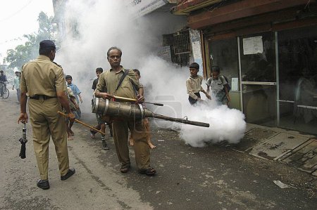 Téléchargez les photos : Travailleur municipal utilisant une machine à brouillard dans la voie pour contrôler le paludisme à Bombay Mumbai, Maharashtra, Inde - en image libre de droit
