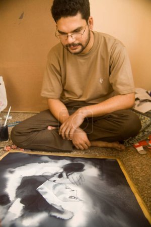 Photo for Contemporary South Asian Indian artist tv Santosh looking at painting - Royalty Free Image