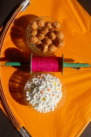 Foto de Cometas; un carrete de manja colorida; Sesame chikki ladoos y azucarillos para celebrar el Festival Makara Sankranti; Bombay ahora Mumbai; Maharashtra; India - Imagen libre de derechos