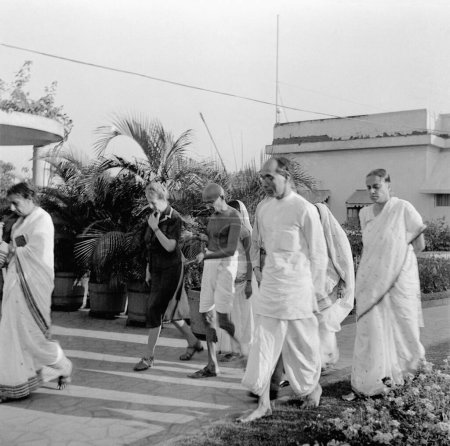 Photo for Rajkumari Amrit Kaur, Agatha Harrison, Mahatma Gandhi, Pyarelal Nayar and others during an evening walk at Birla House, Mumbai, 1945, India - Royalty Free Image