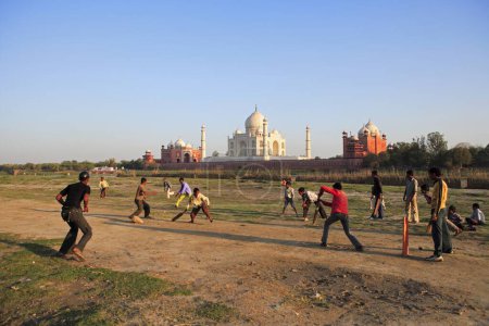 Téléchargez les photos : Enfants jouant au cricket au Taj Mahal Septième merveilles du monde sur la rive sud de la rivière Yamuna, Agra, Uttar Pradesh, Inde Site du patrimoine mondial de l'UNESCO - en image libre de droit
