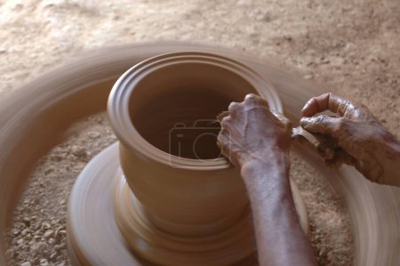 Téléchargez les photos : Poterie ; Le kumbhar indien traditionnel (potier) argile terre fabricant de pot ; Fabrication de pot d'argile sur la roue ; Fabrication rurale de gains ; Malewad ; Shiroda ; Sindhudurga ; Maharashtra ; Inde - en image libre de droit