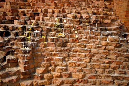 Foto de Vela derretida cera y hojas de oro pegadas en las paredes del santuario de monasterios en ruinas cerca de Dhamekh stupa; Sarnath; Varanasi; Uttar Pradesh; India - Imagen libre de derechos