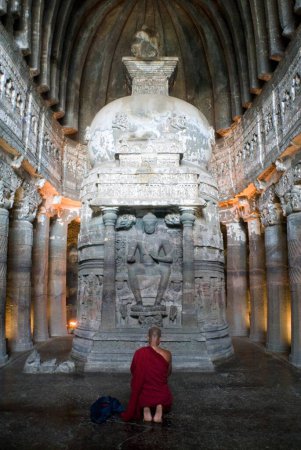 Photo for Buddhist monk praying in front of statue of Buddhist ; Ajanta caves ; Aurangabad ; Maharashtra ; India - Royalty Free Image