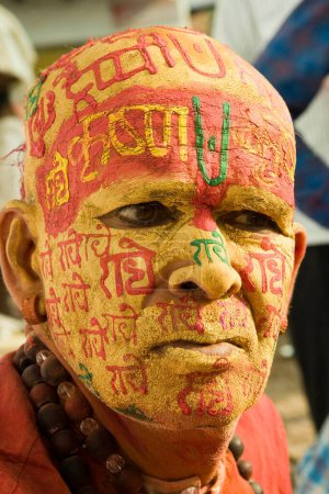 Foto de Sacerdote escribiendo radhe krishna en la cara por pasta de sándalo, uttar pradesh, india, asia - Imagen libre de derechos