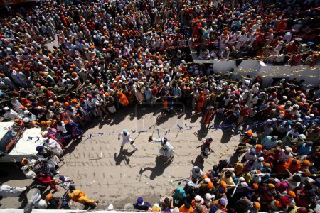 Téléchargez les photos : Guerriers nihang ou sikhs effectuant des cascades avec des épées en bois pendant les célébrations Hola Mohalla à Anandpur sahib dans le district de Rupnagar, Punjab, Inde - en image libre de droit