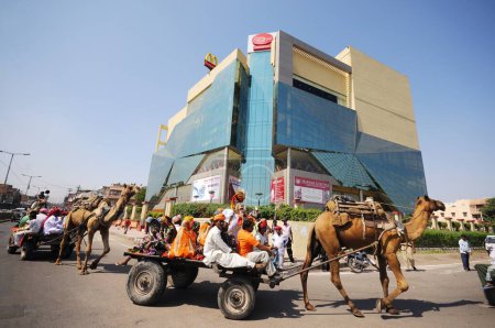 Téléchargez les photos : Personnes assises sur un chariot à chameaux au festival marwar, Jodhpur, Rajasthan, Inde - en image libre de droit