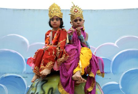 Téléchargez les photos : Festival Janmashtami ou fête d'anniversaire du Seigneur Krishna enfants de carnaval habillés en Krishna et Radha assis sur Globe porté en camion dans la procession, Jabalpur, Madhya Pradesh, Inde - en image libre de droit