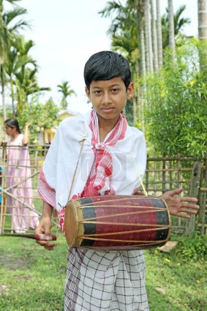 Foto de Niño tocando un instrumento musical y celebrando el festival de Bihu (celebración del año nuevo) Assam, India - Imagen libre de derechos
