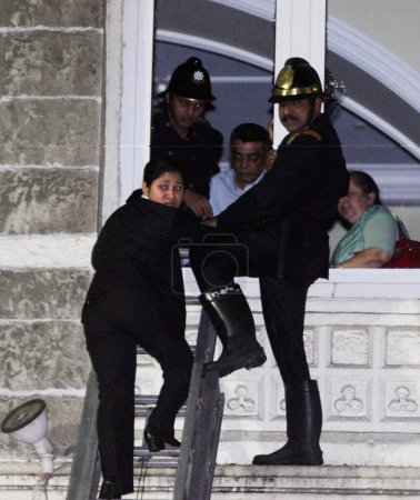 Téléchargez les photos : Officier des pompiers en charge du sauvetage en échelle des otages depuis la fenêtre de l'hôtel Taj Mahal lors de l'attaque terroriste des Moudjahidines Deccan, Bombay Mumbai, Maharashtra, Inde 26 novembre 2008 - en image libre de droit