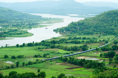 Konkan ferrocarril que pasa a través de arrozales arrozales y vashishti río, Chiplun, Ratnagiri, Maharashtra, India