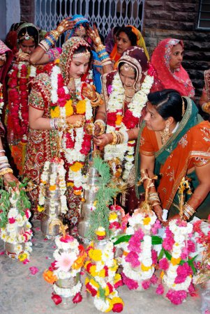 Téléchargez les photos : Rajasthani Marwari femmes préparant des pots en argent lotiyan ou en métal à l'occasion de Gangaur, Jodhpur, Rajasthan, Inde - en image libre de droit