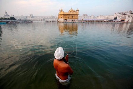 Téléchargez les photos : Sikh offrant ses prières à Harmandir Sahib ou Darbar Sahib ou temple d'or ; à Amritsar ; Pendjab ; Inde - en image libre de droit