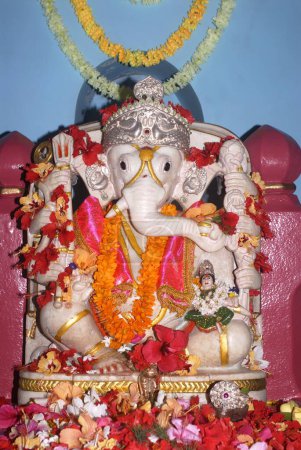 Photo for Marble idol of Lord Ganesh sitting on a throne in the sanctuary of  Shri Dasabhuj Lakshmi Ganesh temple at Hedvi ; Konkan region ; Taluka Guhagar ; District Ratnagiri ; Maharashtra ; India - Royalty Free Image