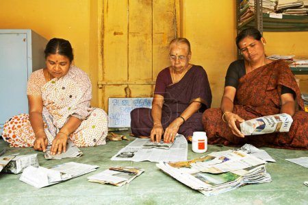 Téléchargez les photos : Bénévoles de l'ONG Chinmaya Organization of Rural Development CORD fabriquant des sacs en papier recyclé à partir de vieux journaux, Siruvani, Karnataka, Inde - en image libre de droit