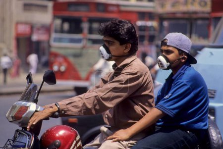 Téléchargez les photos : Pollution de la route, motos cyclistes portant un masque - en image libre de droit
