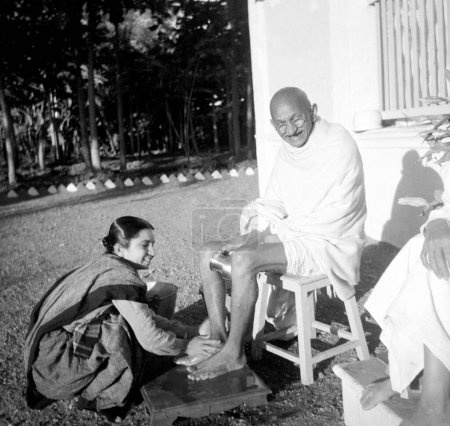 Foto de Ashramite Dr. Lilavatibehn Asha lavando los pies de Mahatma Gandhis en Bardoli, 1939, India - Imagen libre de derechos