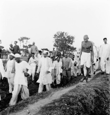 Foto de Mahatma Gandhi y otros caminando a través de campos abiertos en las zonas afectadas por disturbios de Bihar; 1947; India - Imagen libre de derechos