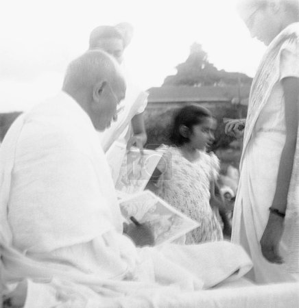Téléchargez les photos : Après la prière Mahatma Gandhi donne un autographe, Pune, 2 oct 1944 - en image libre de droit