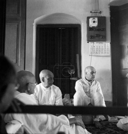 Foto de Mahatma Gandhi, sus compañeros de trabajo Sardar Vallabhbhai Patel y Jawaharlal Nehru escuchan un informe sobre disturbios en Calcuta, Bengala Occidental, India, 1946 - LIBERACIÓN DEL MODELO NO DISPONIBLE - Imagen libre de derechos
