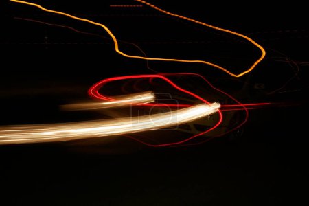 Photo for Streaks of head and tail lights of speeding car and street lamps at night in race held at the Balewadi sports complex, Pune, Maharashtra, India  pr on 5th may; 2006 - Royalty Free Image