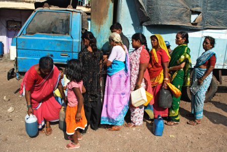 Téléchargez les photos : Dames en file d'attente pour le kérosène distribué dans le magasin de ration à Bombay Mumbai, Maharashtra, Inde 17, Avril, 2009 - en image libre de droit