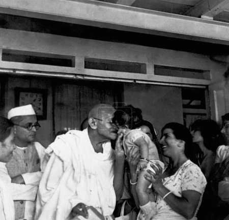 Foto de Anand Hingorani, Mahatma Gandhi, hija y esposa Gulbehn del Dr. Dinshah Mehta en la clínica de curación de la naturaleza en Pune, 1944 - Imagen libre de derechos