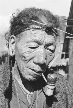 Photo for Member of Apa Tani tribe enjoys pipe smoking Ziro District headquarters of Lower Subansiri, Arunachal Pradesh, India 1982 - Royalty Free Image