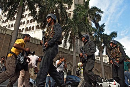 Foto de Comandos de la Guardia Nacional de Seguridad NSG con arma de fuego fuera del hotel Taj Mahal hotel después del ataque terrorista de muyahidines decanos, Bombay Mumbai, Maharashtra, India 29 de noviembre de 2008 - Imagen libre de derechos